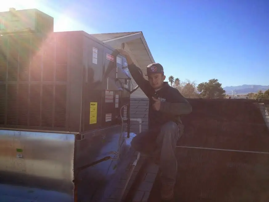 HVAC technician performing Heat Pump Repair on a rooftop unit in Miamisburg